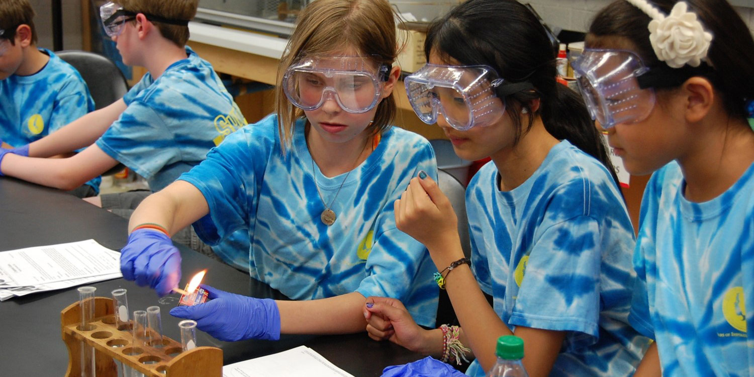 Three students wearing safety goggles