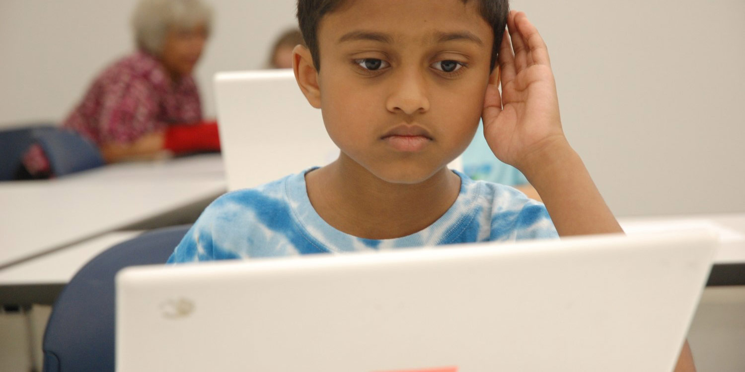 Student leaning on a computer